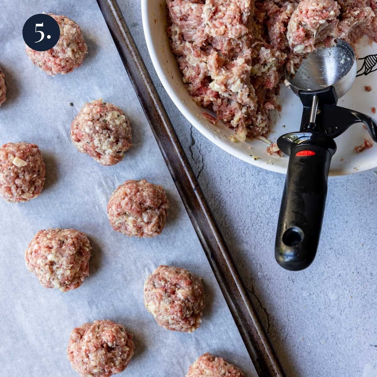 portioning meatballs with an ice cream scoop onto a parchment lined baking sheet