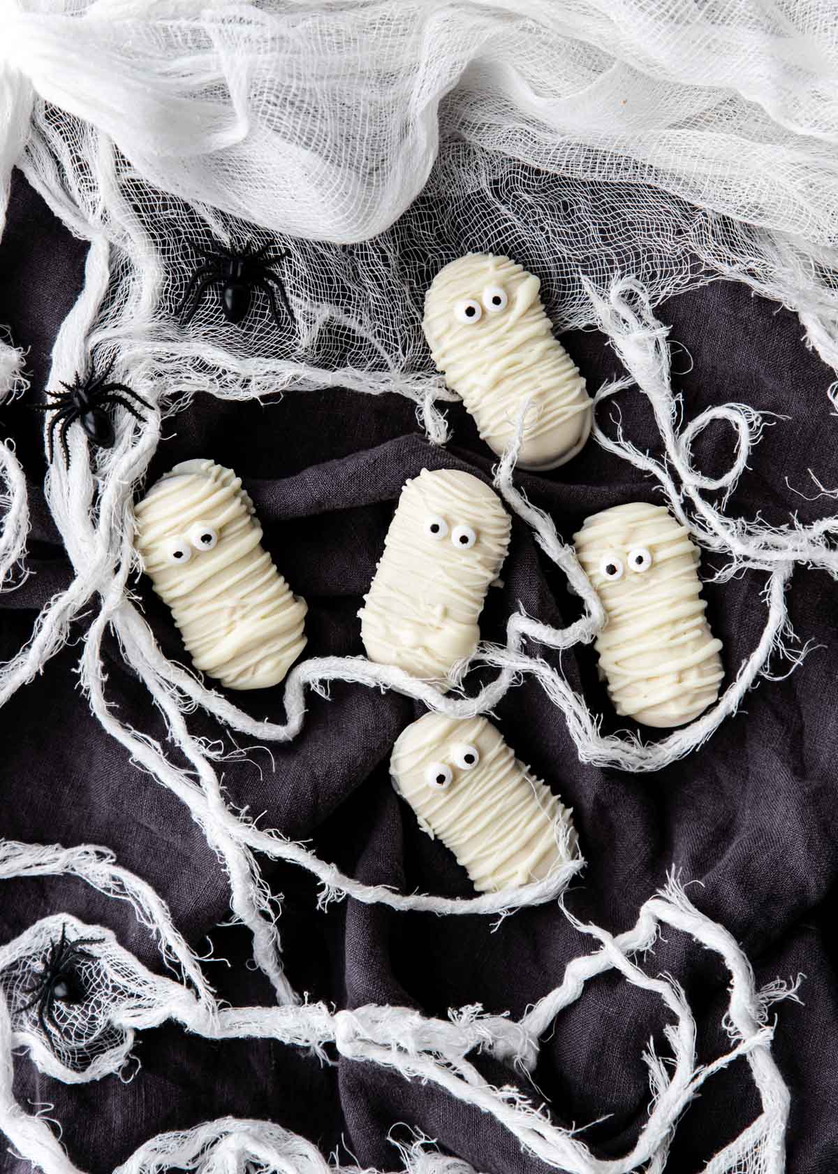 Mummy Cookies on a black surface with gauze around