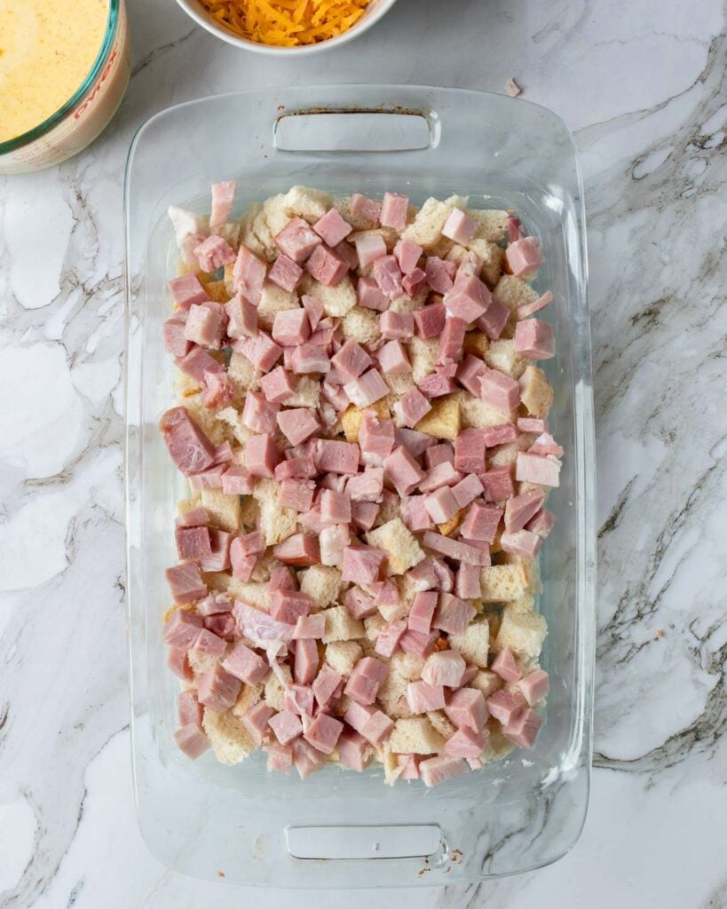 bread cubes and cubed ham in a buttered 9x13 casserole pan