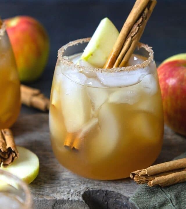 apple cider margarita with an apple slice and cinnamon stick