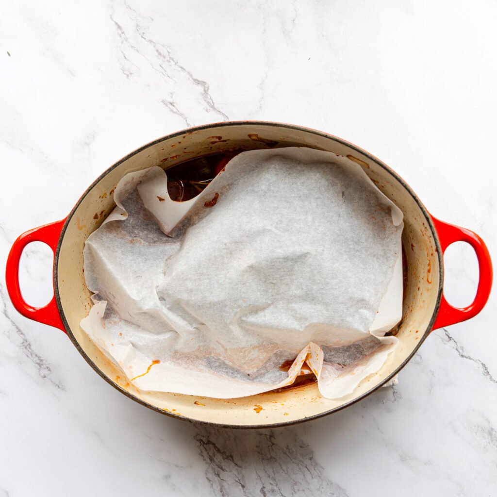 parchment paper tucked around a tri tip in a dutch oven