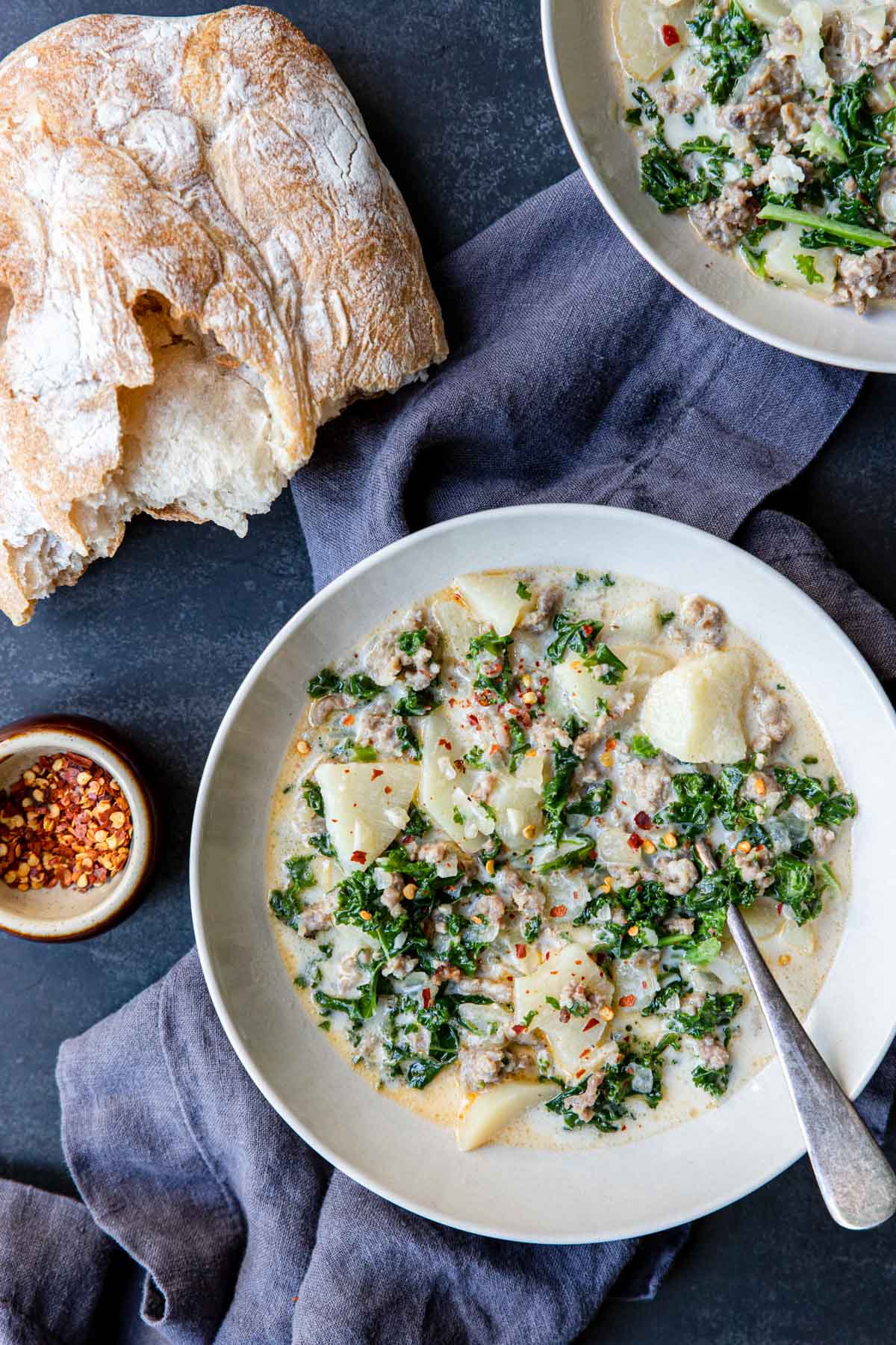 copycat zuppa toscana in a bowl with bread to the side