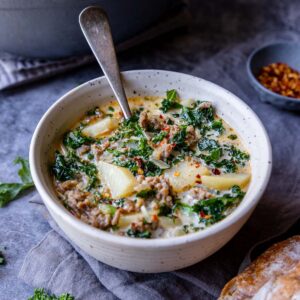 a bowl of zuppa toscana with a spoon