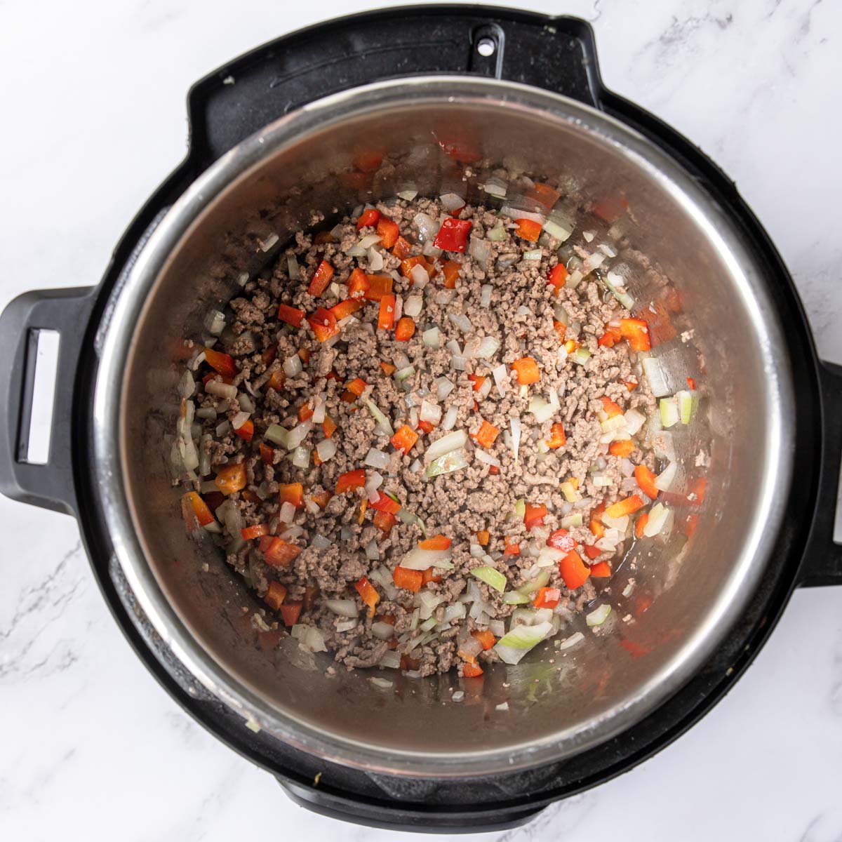 Instant Pot with ground beef, onions and bell peppers.