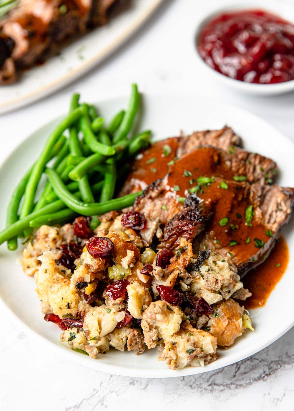 sausage stuffing on a plate with beef and green beans