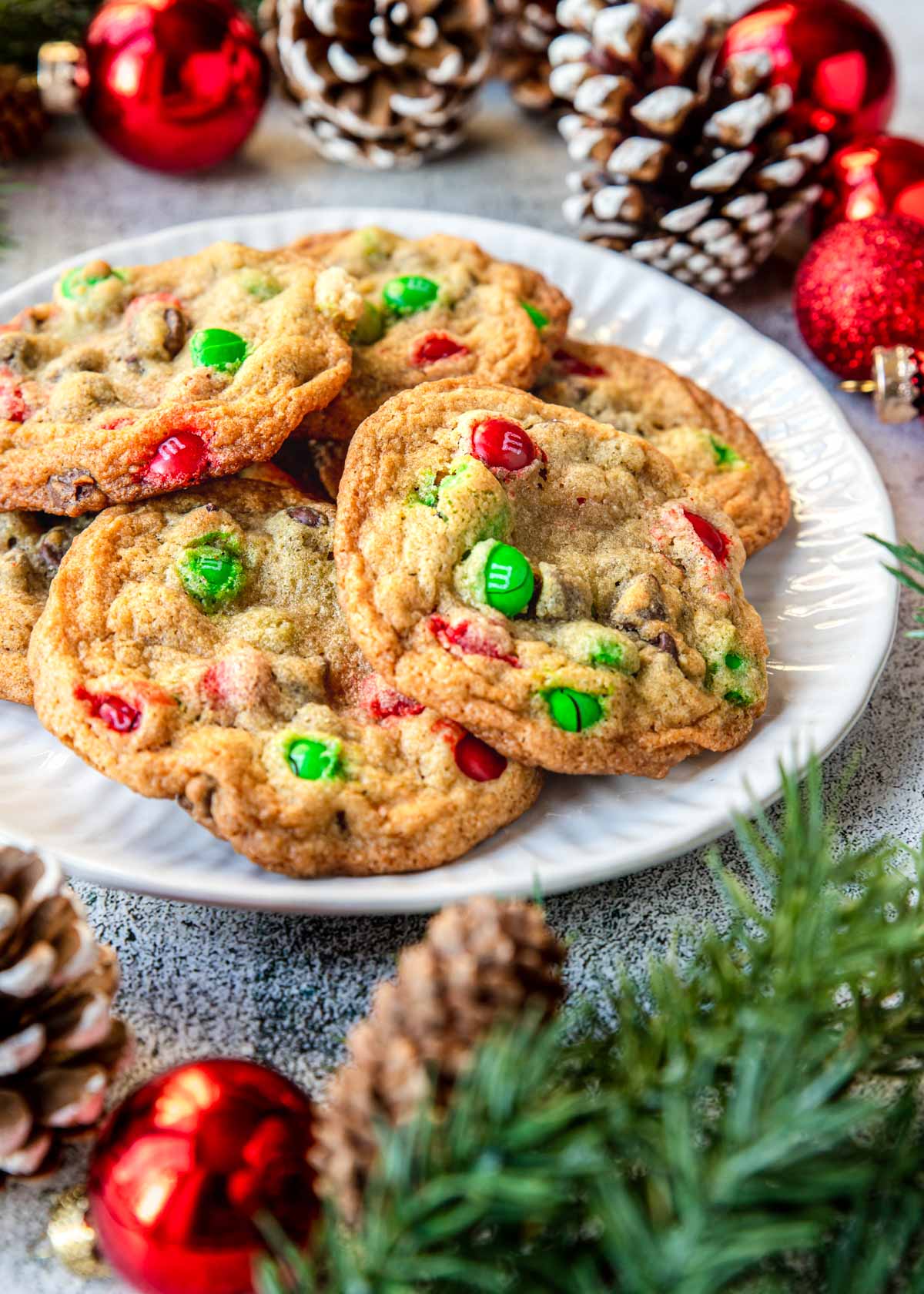 a plate of chocolate chip cookies with red and green m&m's