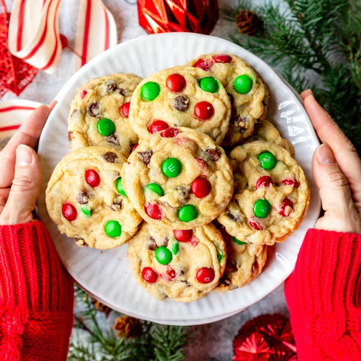 a large plate full of Christmas Chocolate Chip Cookies with Christmas red and green M&M's