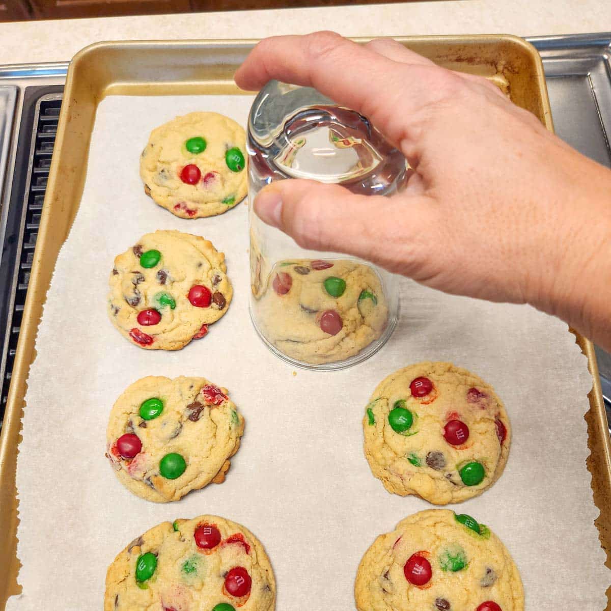 shaping hot cookies with a drinking glass