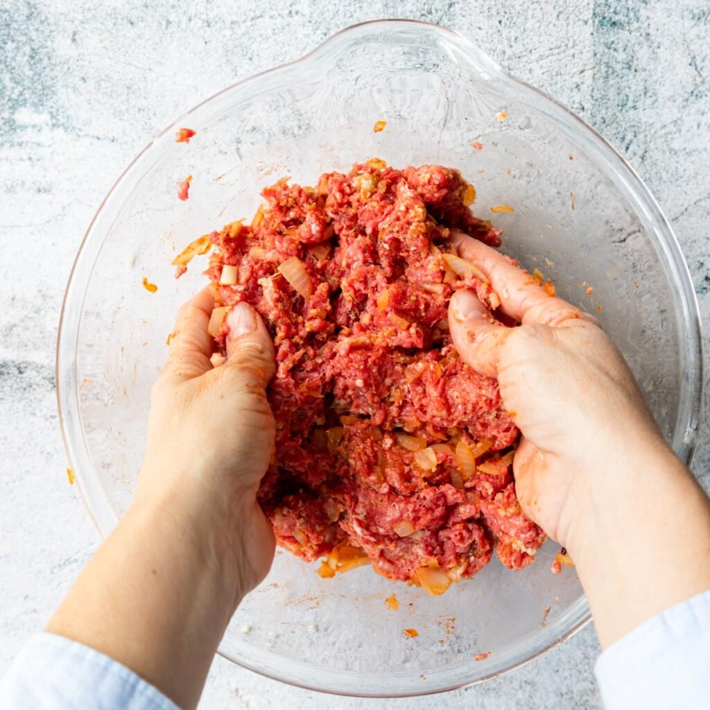 hands combining meatloaf mix in a bowl