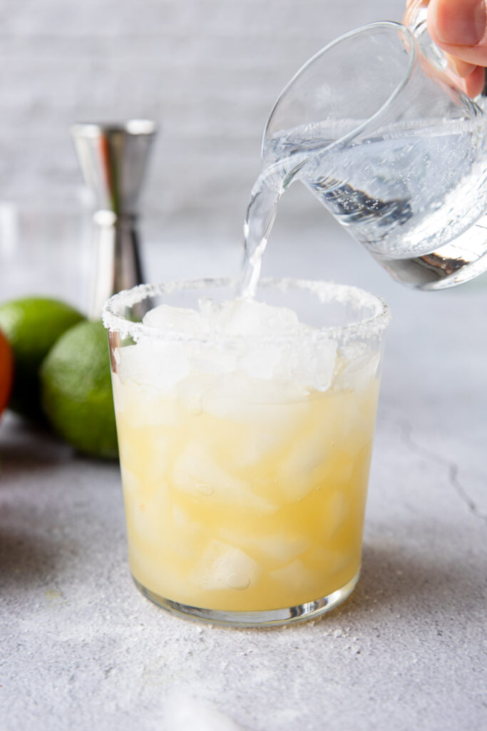pouring tonic into a mock margarita