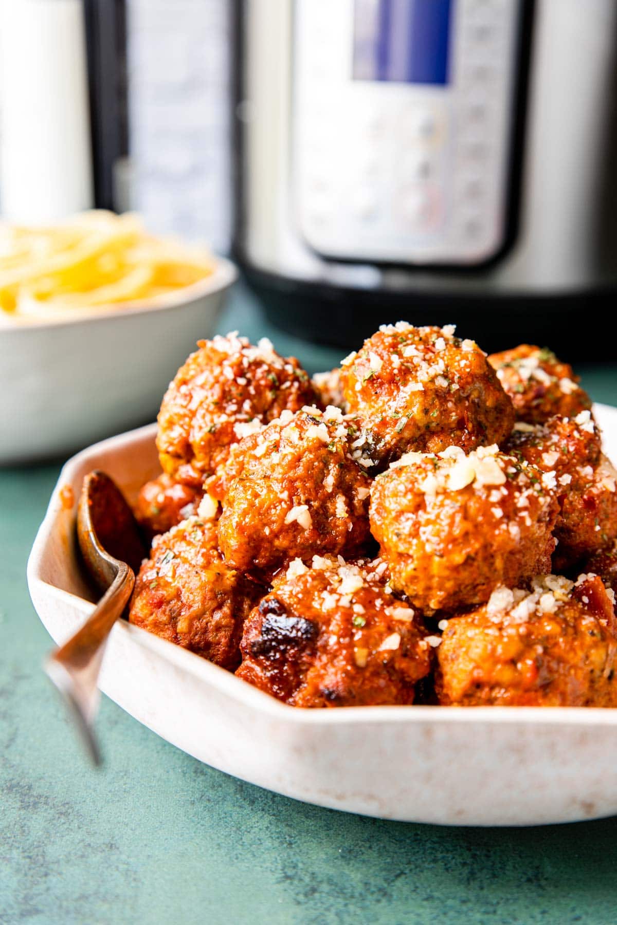 a bowl of Italian Meatballs with spaghetti and an Instant Pot in the background