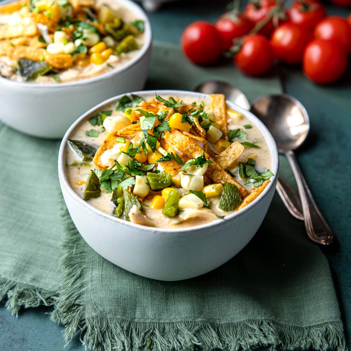 chicken poblano soup in a bowl topped with sour cream and tortilla strips