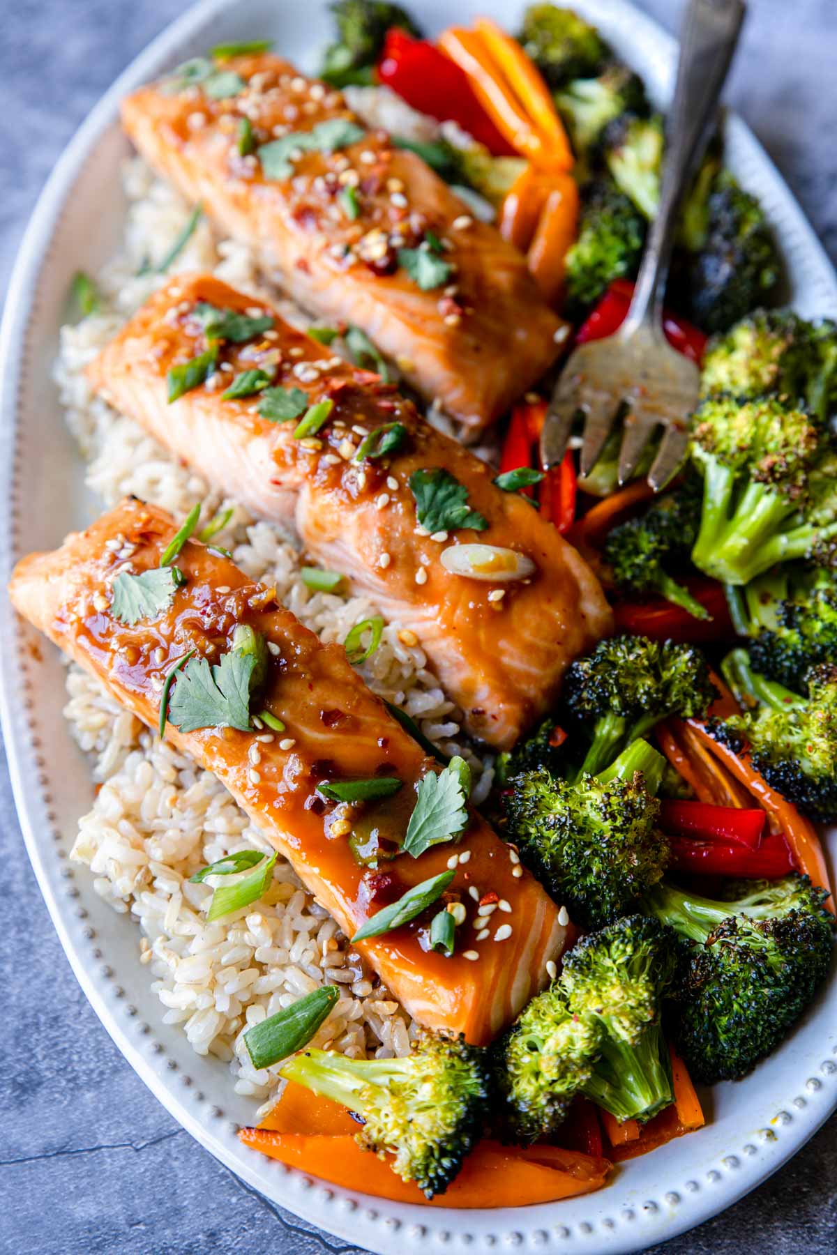 a serving plate with Asian glazed salmon with veggies and rice