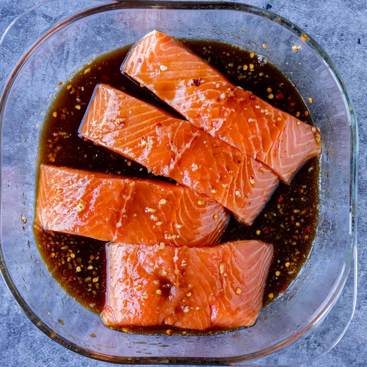 Salmon fillets in a shallow dish with Asian marinade