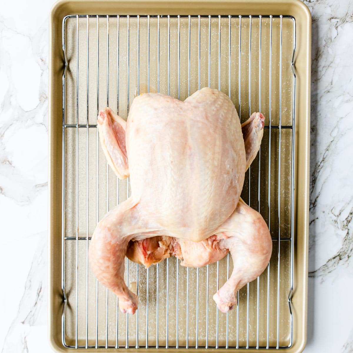 Chicken on a wire rack on a rimmed sheet pan