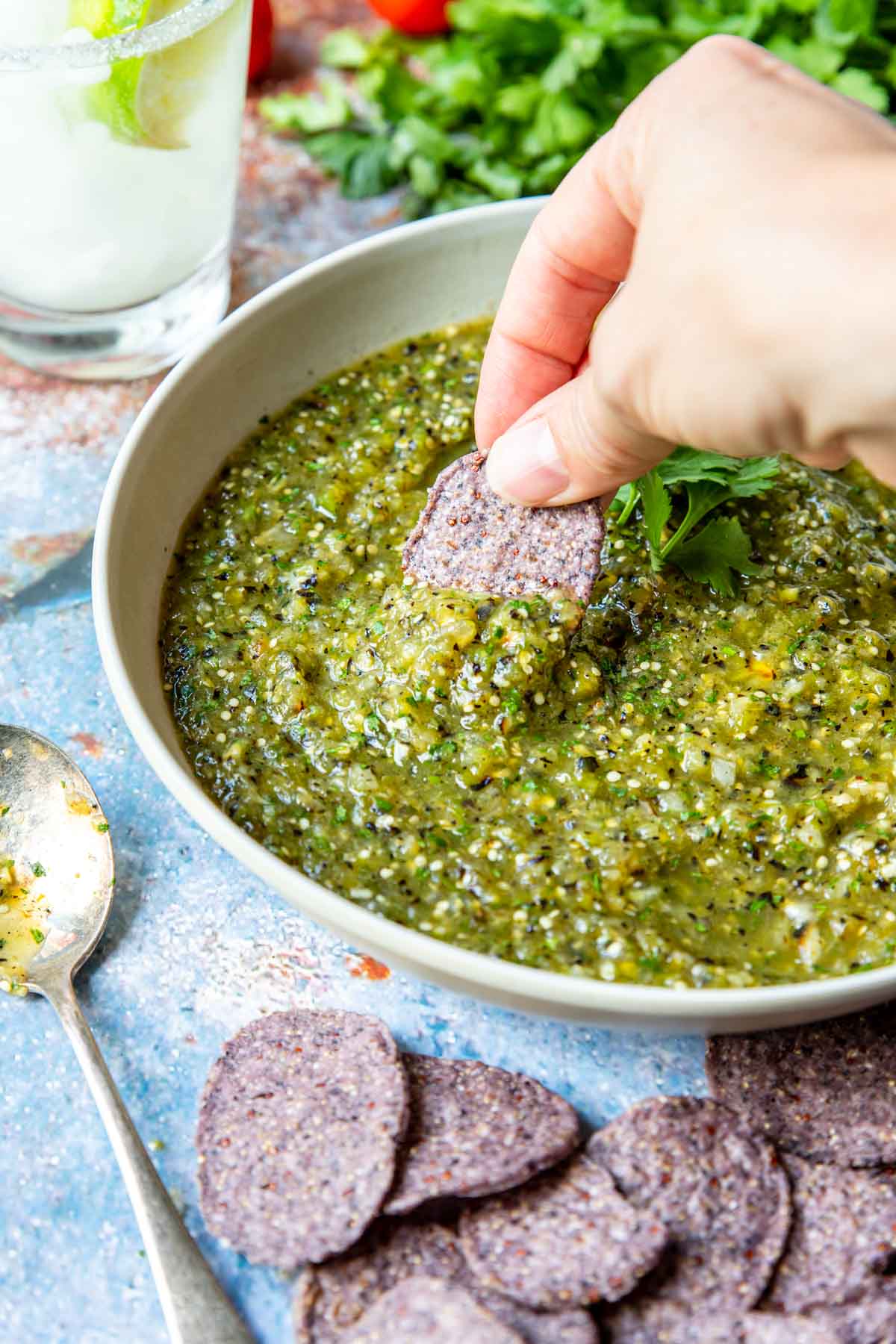 Grilled Tomatillo Salsa being scooped with a tortilla chip