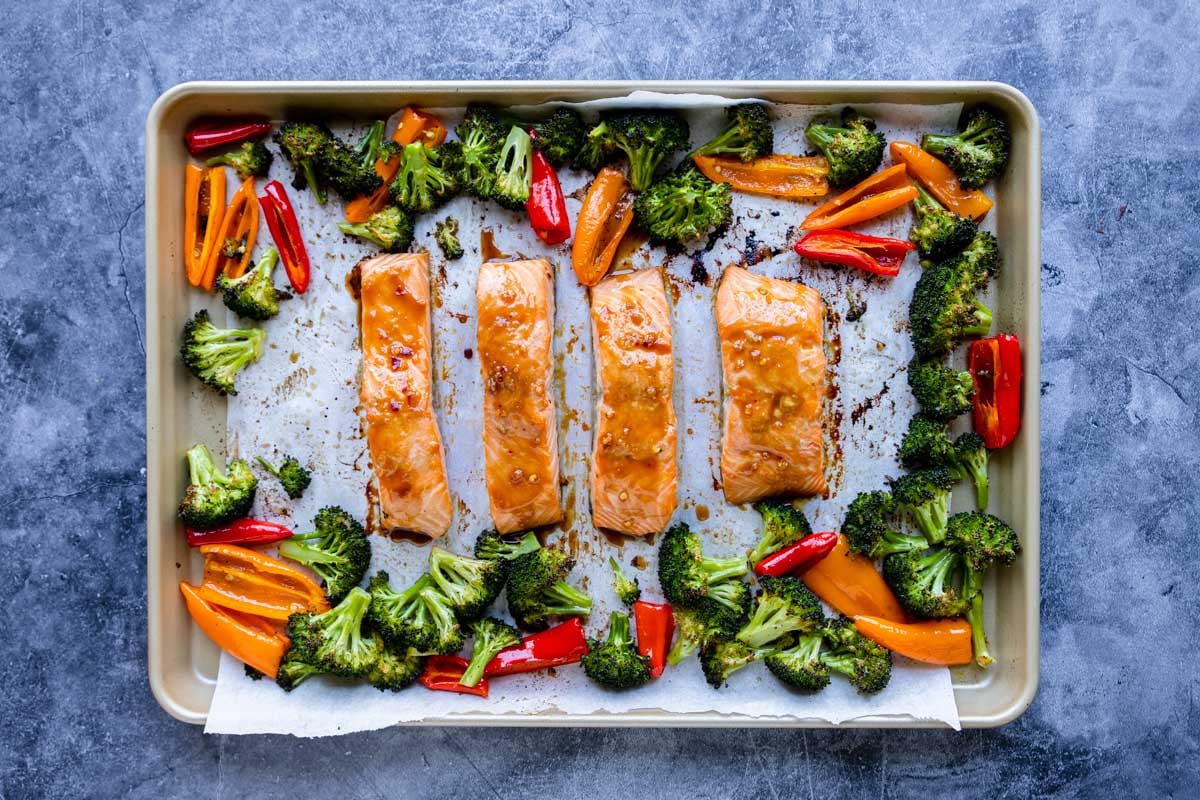 Asian Glazed Salmon on a rimmed sheet pan with broccoli and peppers