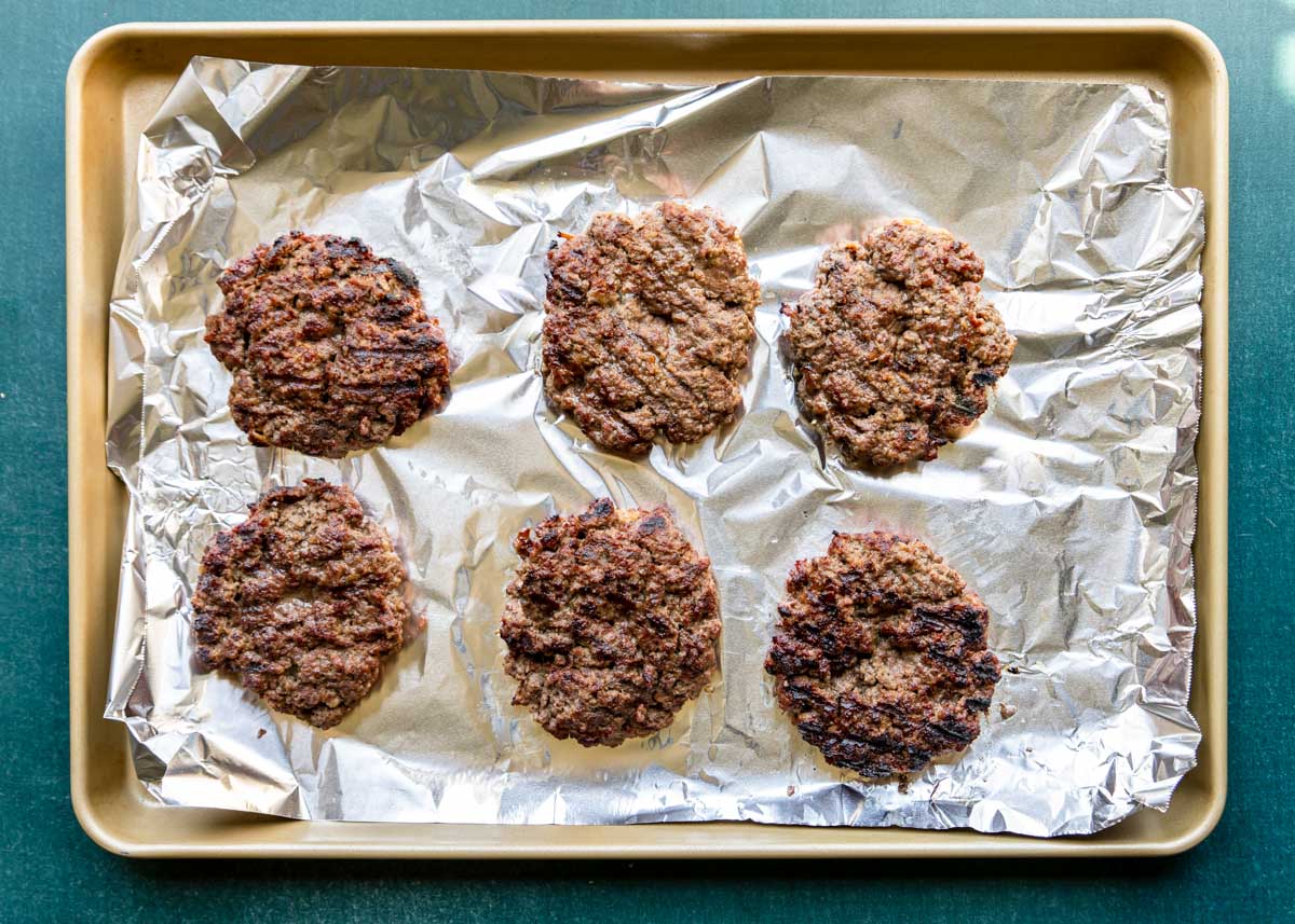 grilled burgers on a baking sheet, straight from the grill