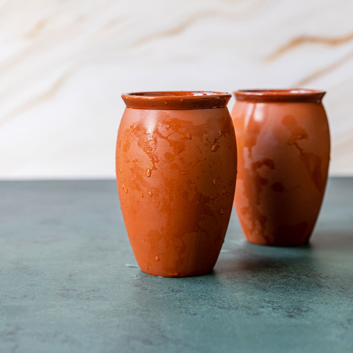 two clay cups also called jarritos de barro that have been soaked in water, these cups are used for cantarito drinks