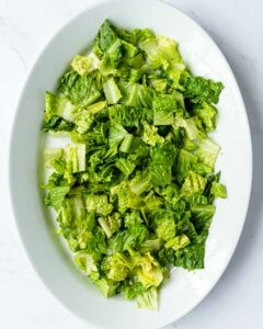 romaine on a platter that has been dressed with basil vinaigrette