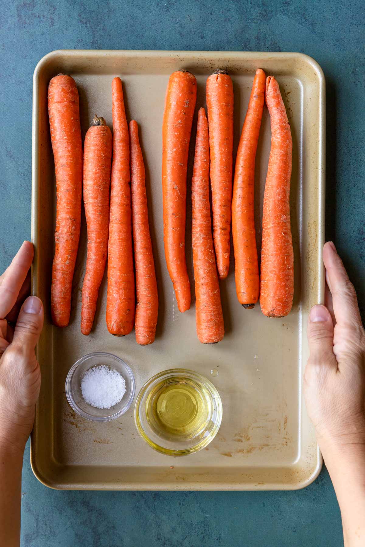 carrots with olive oil and kosher salt on a baking sheet