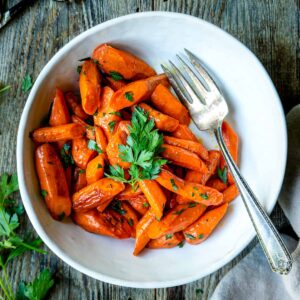 a bowl of roasted carrots garnished with parsley