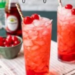 cherry shirley temple drink on a table garnished with maraschino cherries