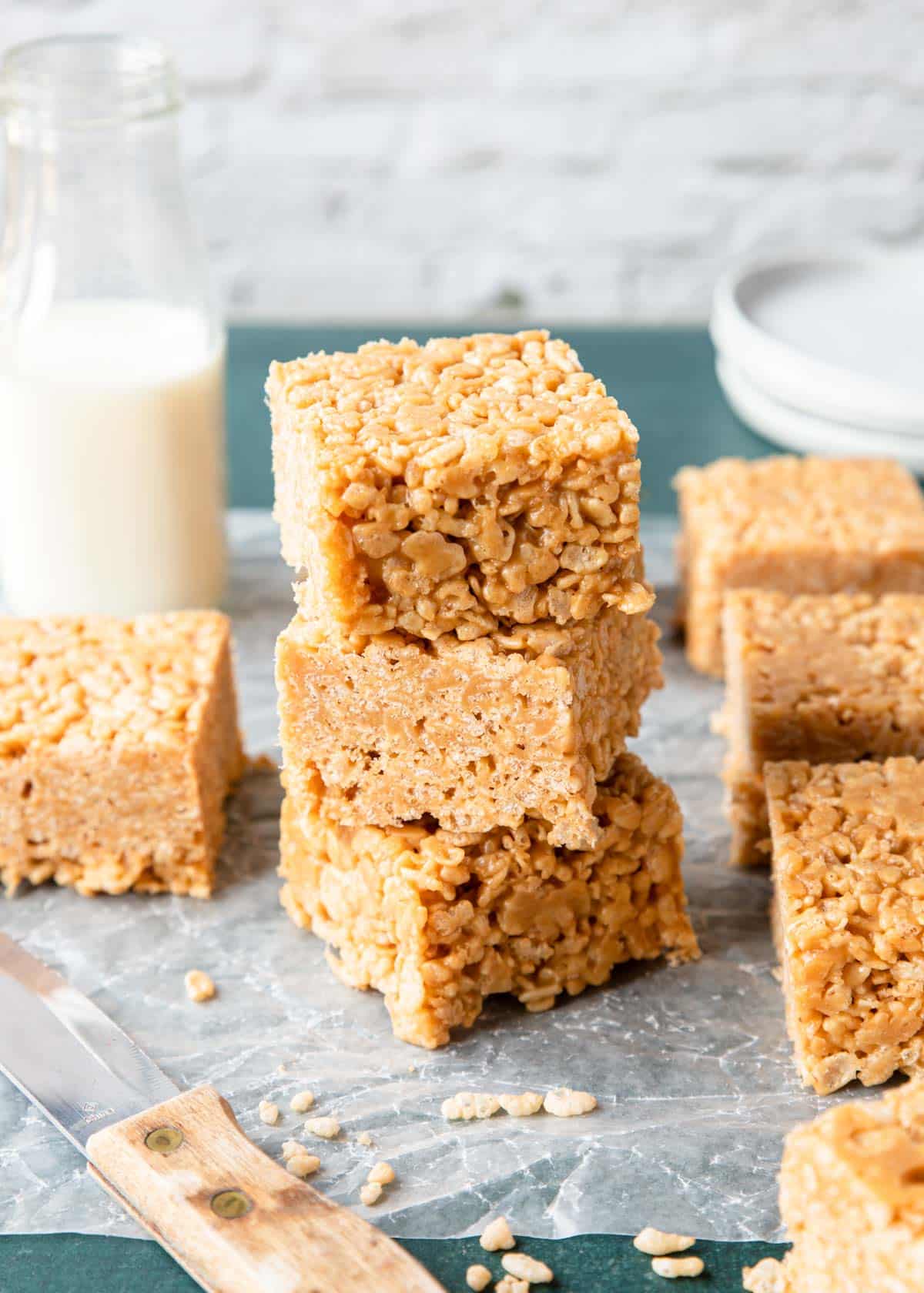 a stack of rice krispies with a glass of milk 