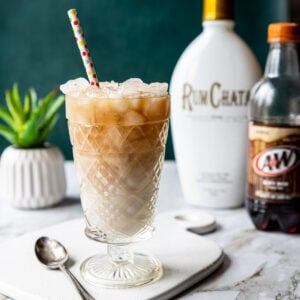rumchata root beer drink in a glass with a bottle of rumchata behind