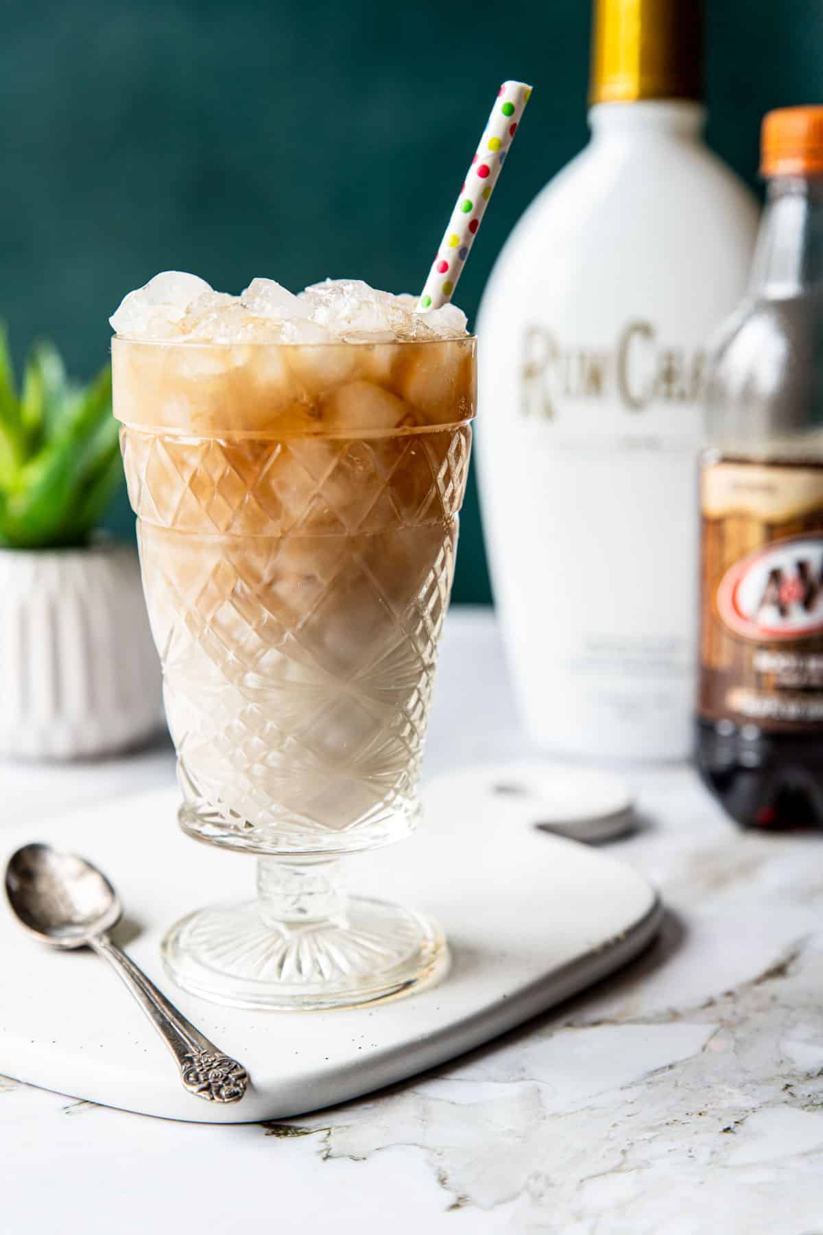 rumchata root beer drink in a glass with a bottle of rumchata behind