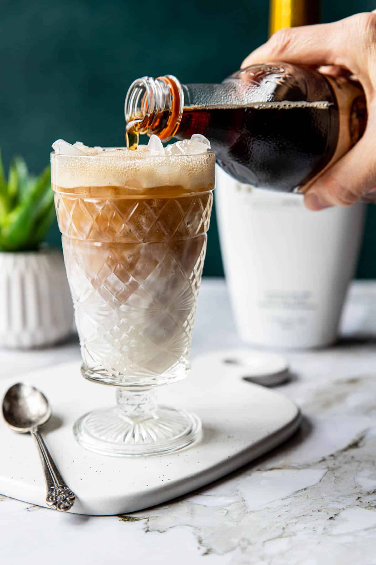 pouring root beer into a glass 