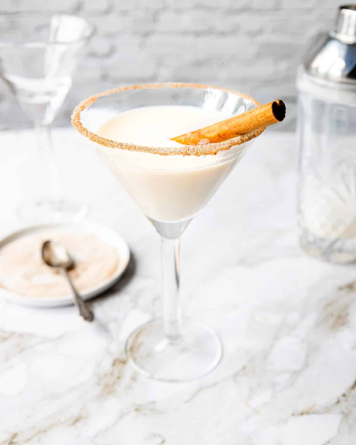 Cinnamon Toast Crunch Drink in a martini glass with a cinnamon stick garnish