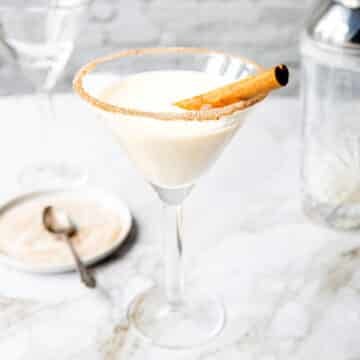 Cinnamon Toast Crunch Cocktail in a martini glass with a cinnamon stick