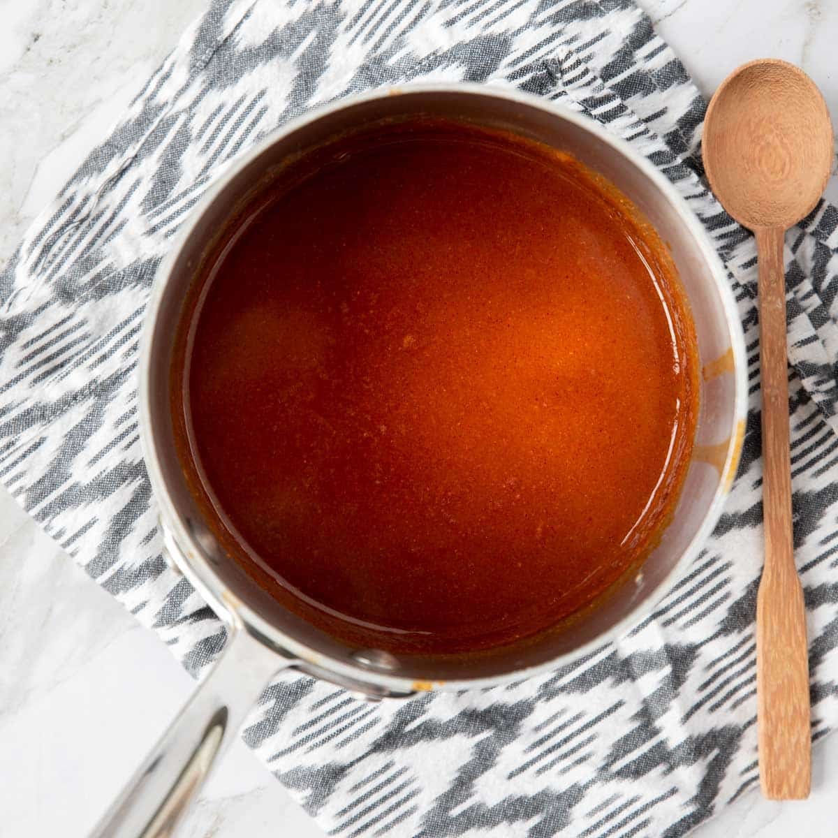 enchilada sauce recipe in a saucepan with a spoon to the side