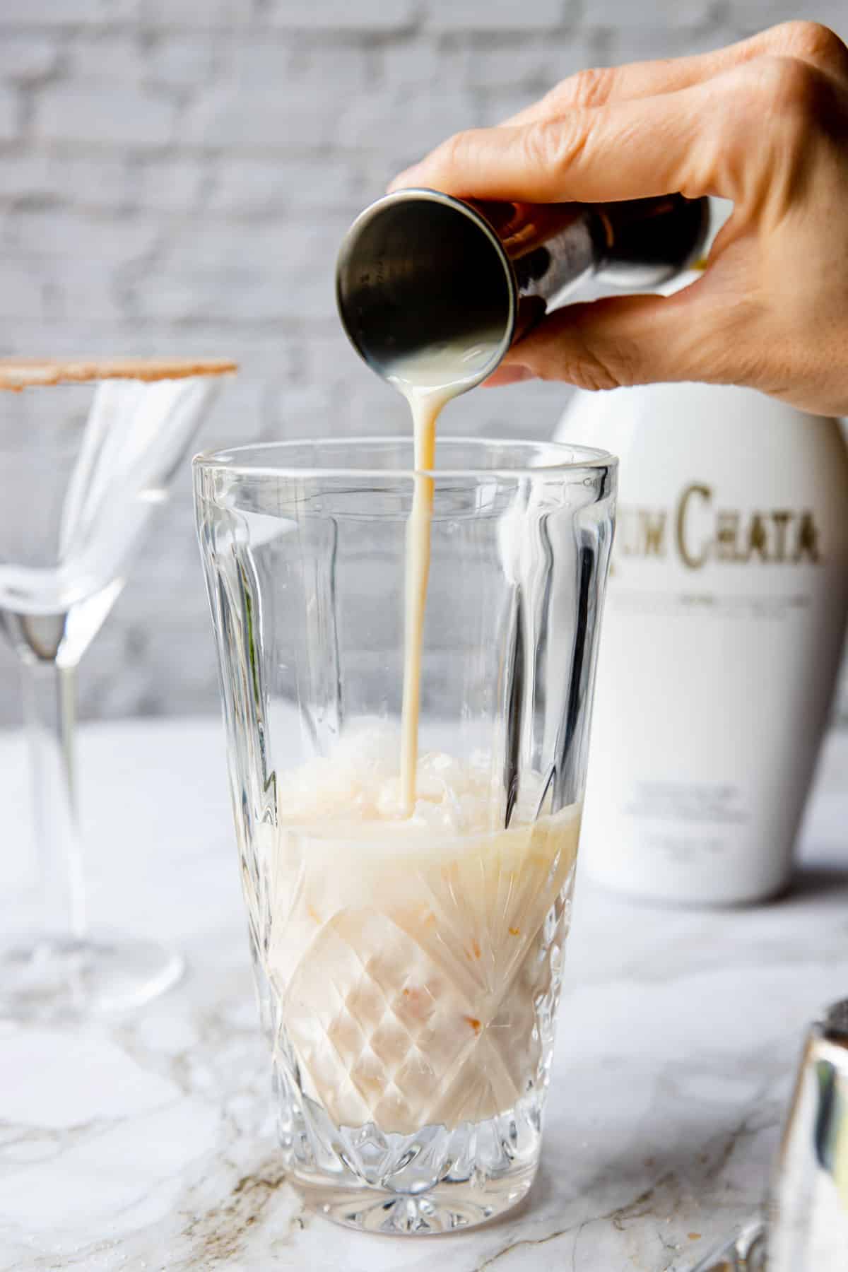 pouring RumChata into a cocktail shaker