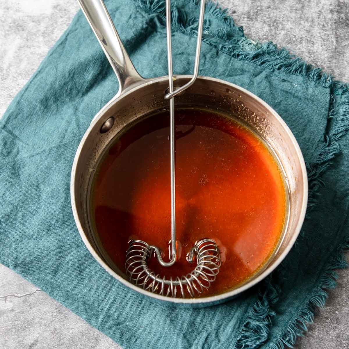 dressing for Asian Slaw in a sauce pan with a whisk