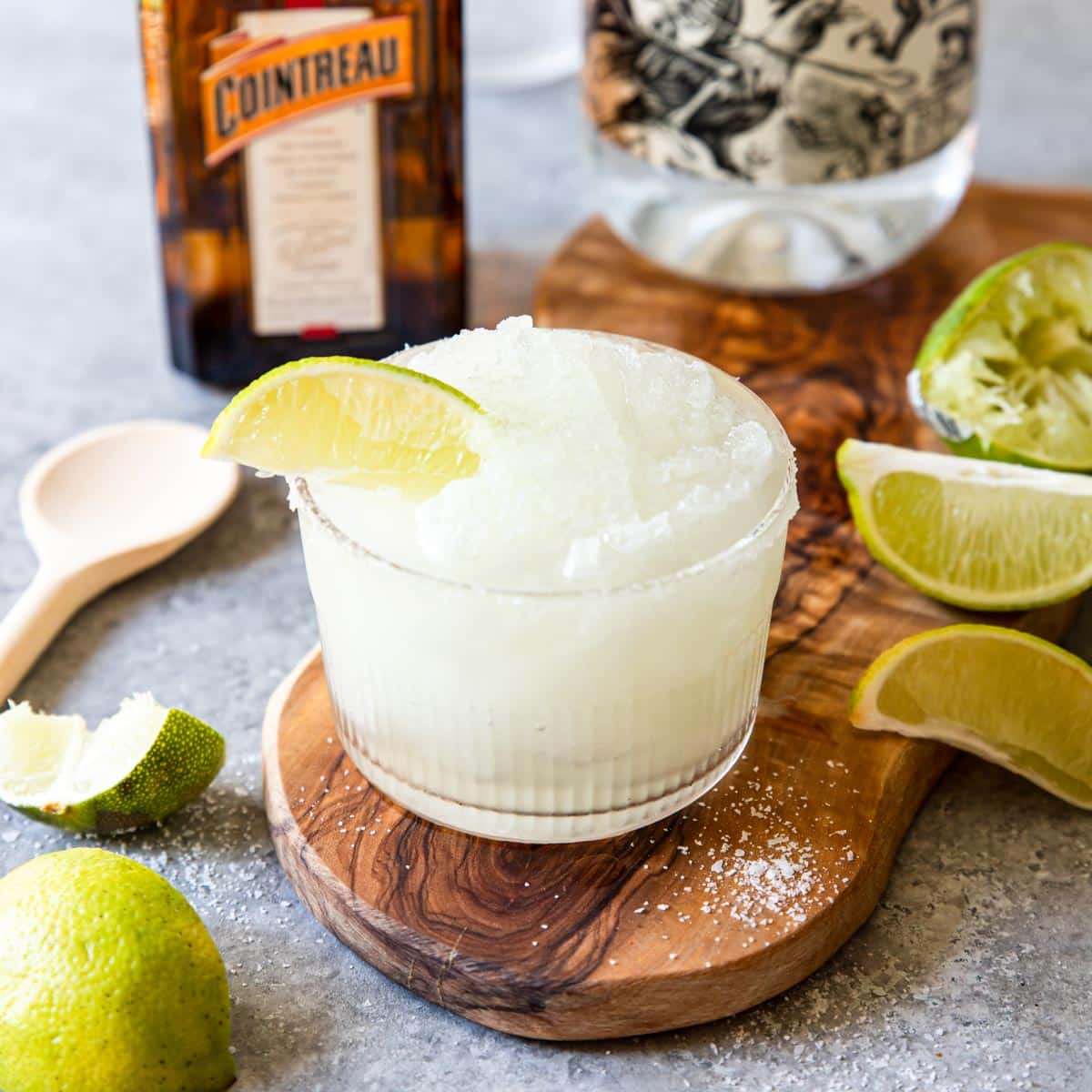 Frozen Margarita in a glass with a kosher salt rim and a lime wedge