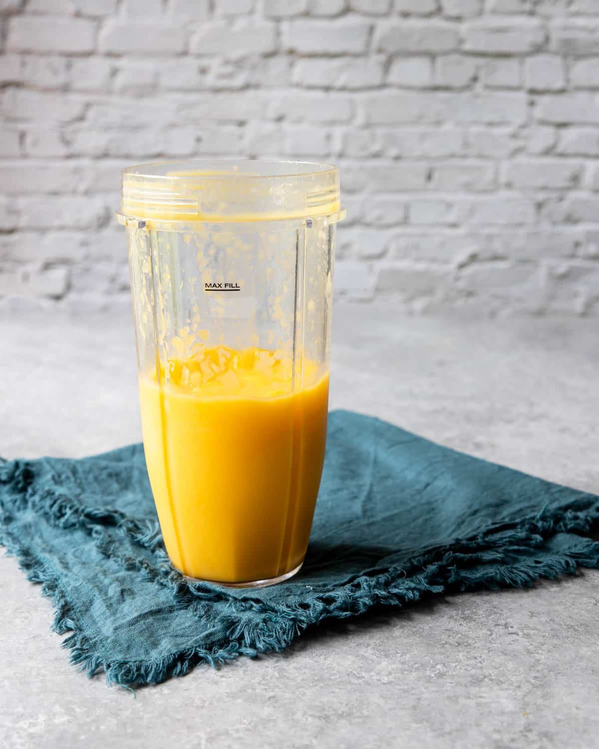 frozen mango margarita in a blender cup