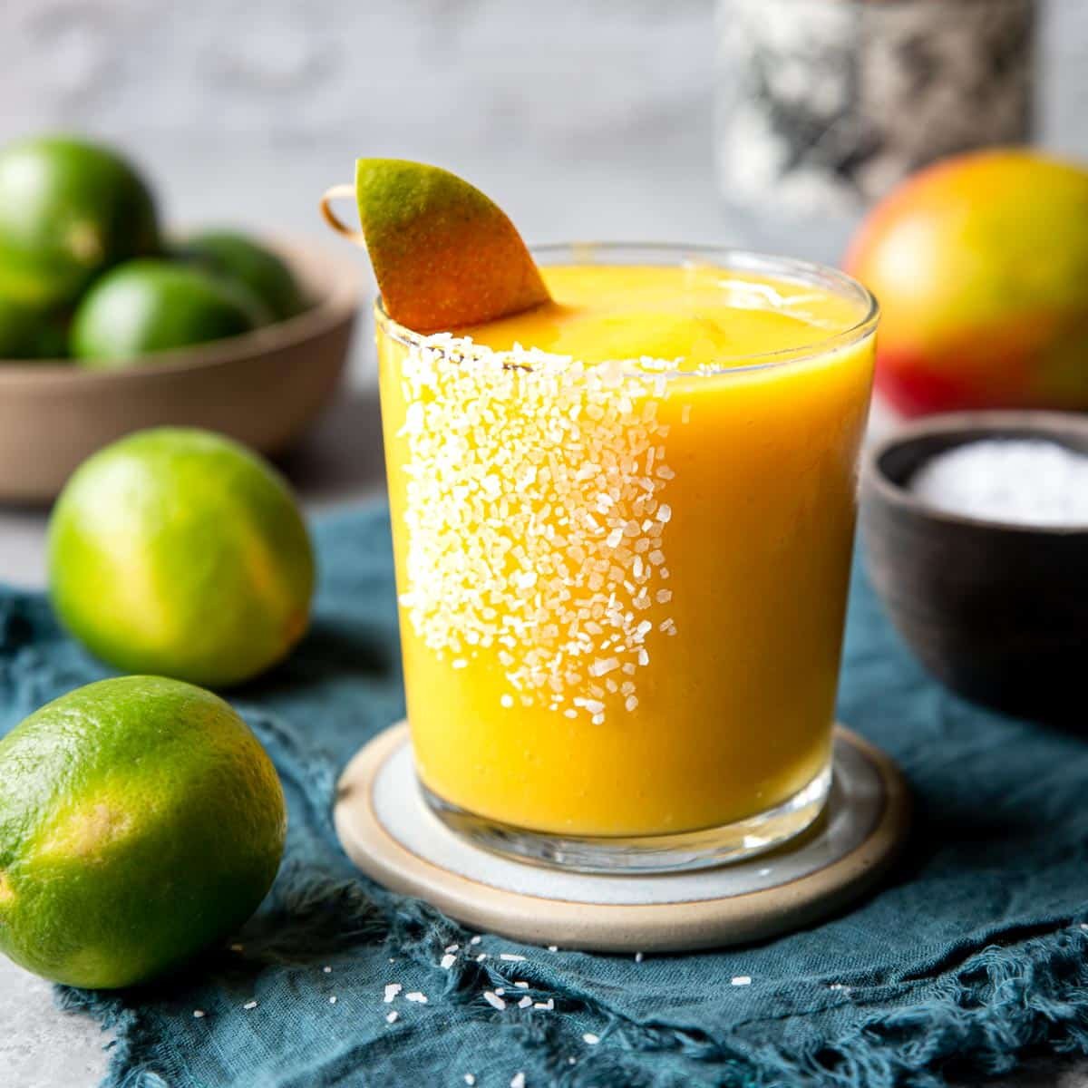 Frozen Mango Margarita in a glass with kosher salt and sugar on the rim