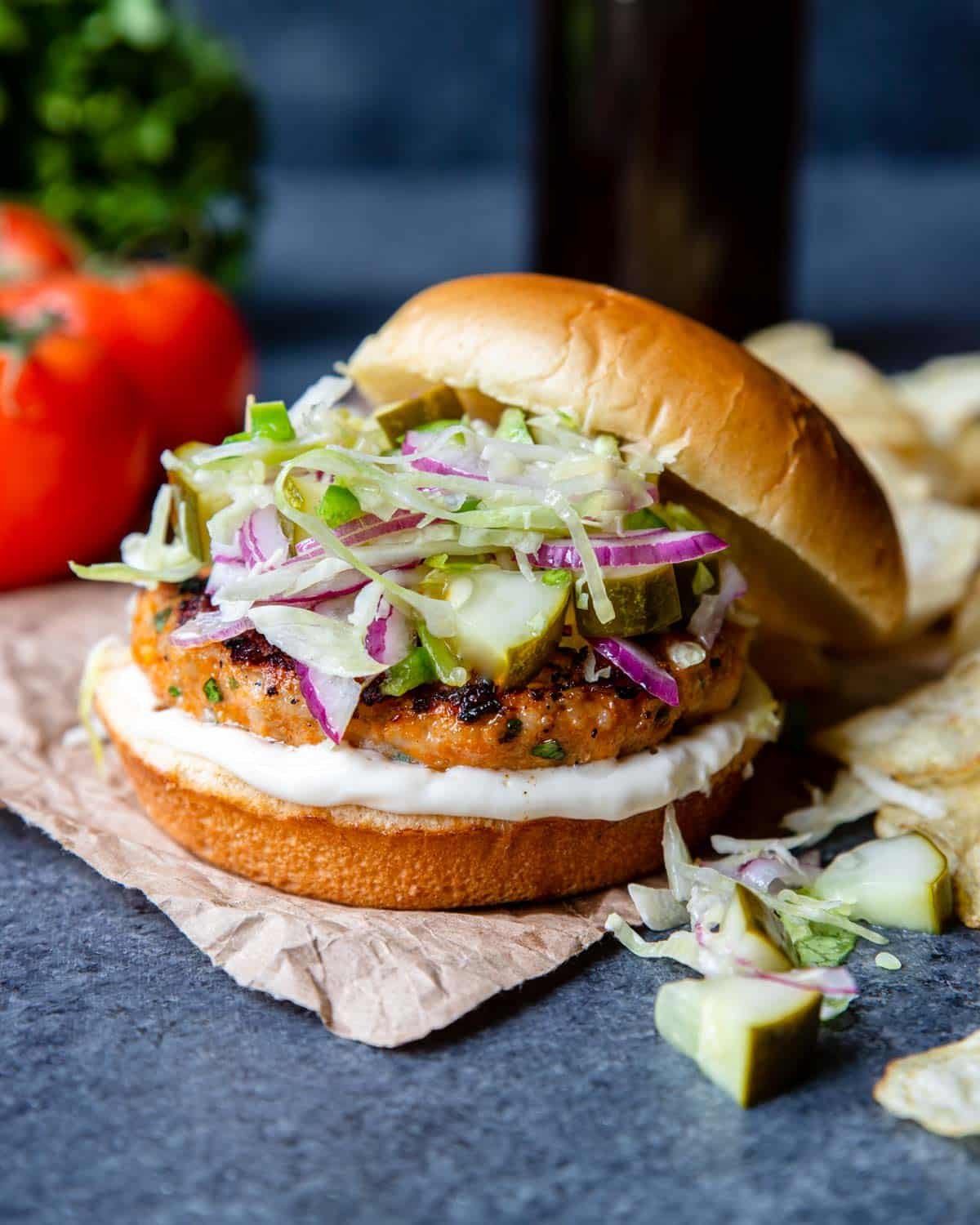 Grilled chicken burger on a bun with pickle slaw and aioli 