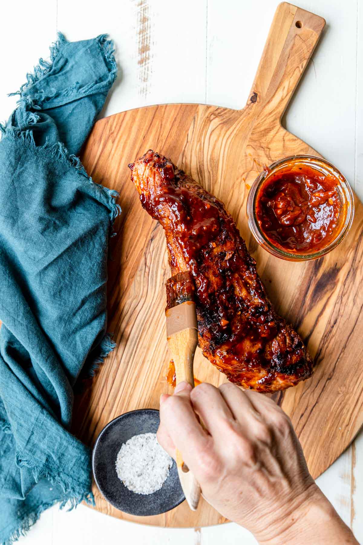 Homemade BBQ Sauce being brushed on a grilled pork tenderloin