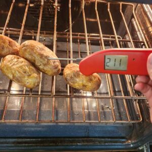 Taking baked potato temperature in the oven to see if it is done, 211 degrees Fahrenheit