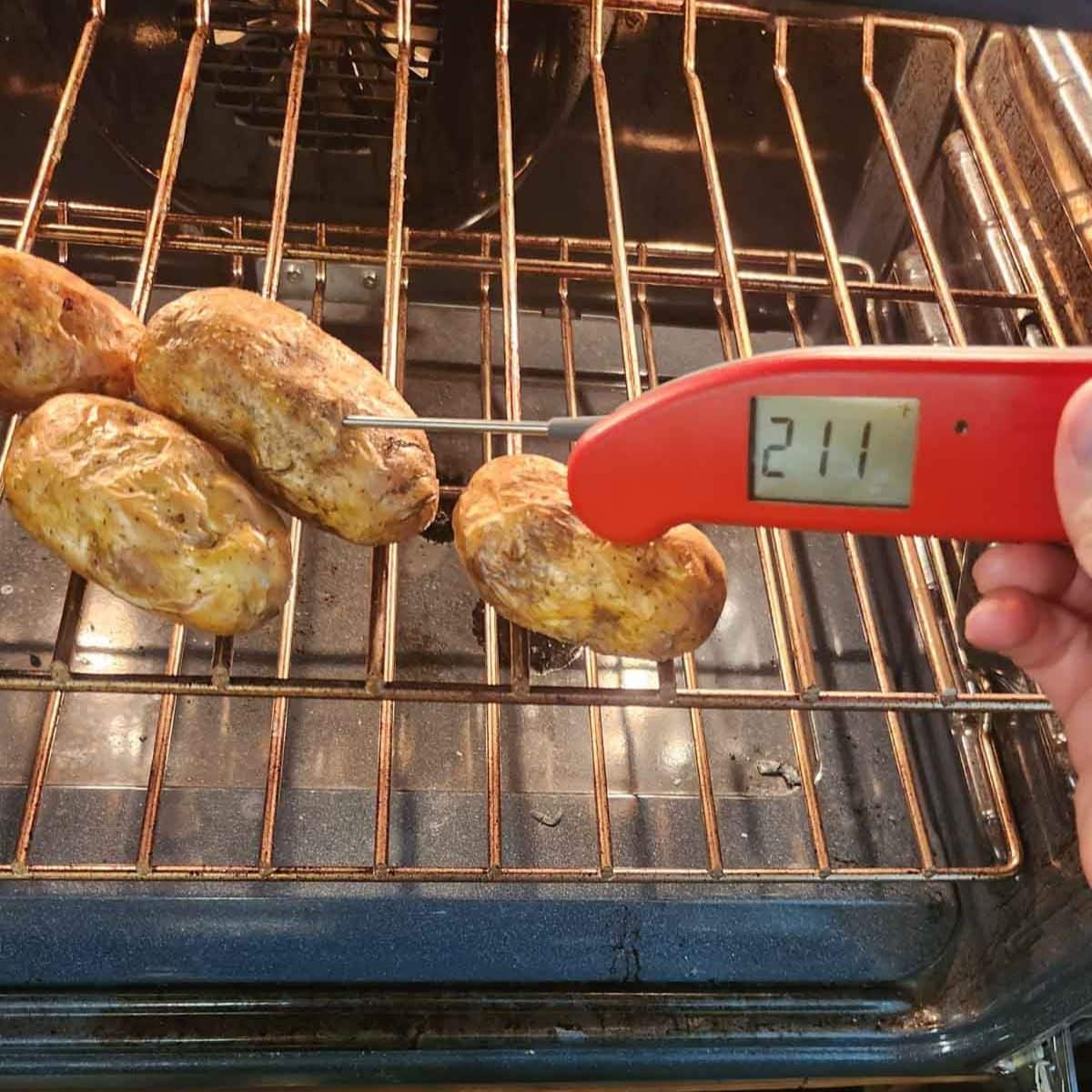 Taking baked potato temperature in the oven to see if it is done, 211 degrees Fahrenheit