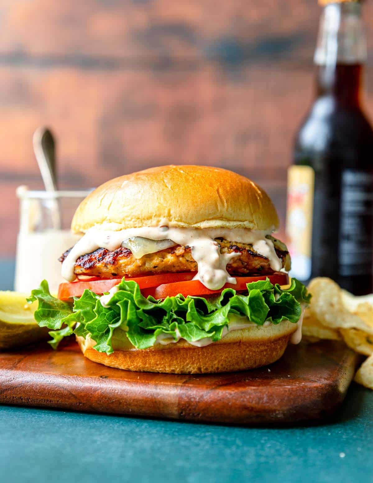 grilled chipotle burger on a brioche bun with lettuce tomato and pepper jack cheese