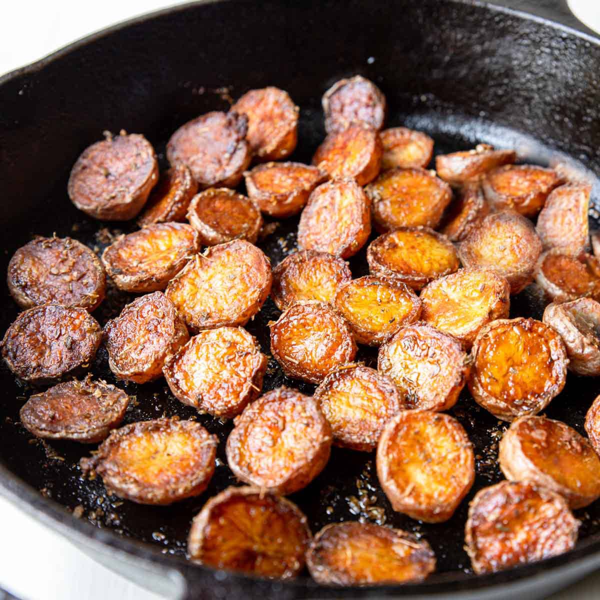 a large cast iron skillet full of cooked crispy little potatoes