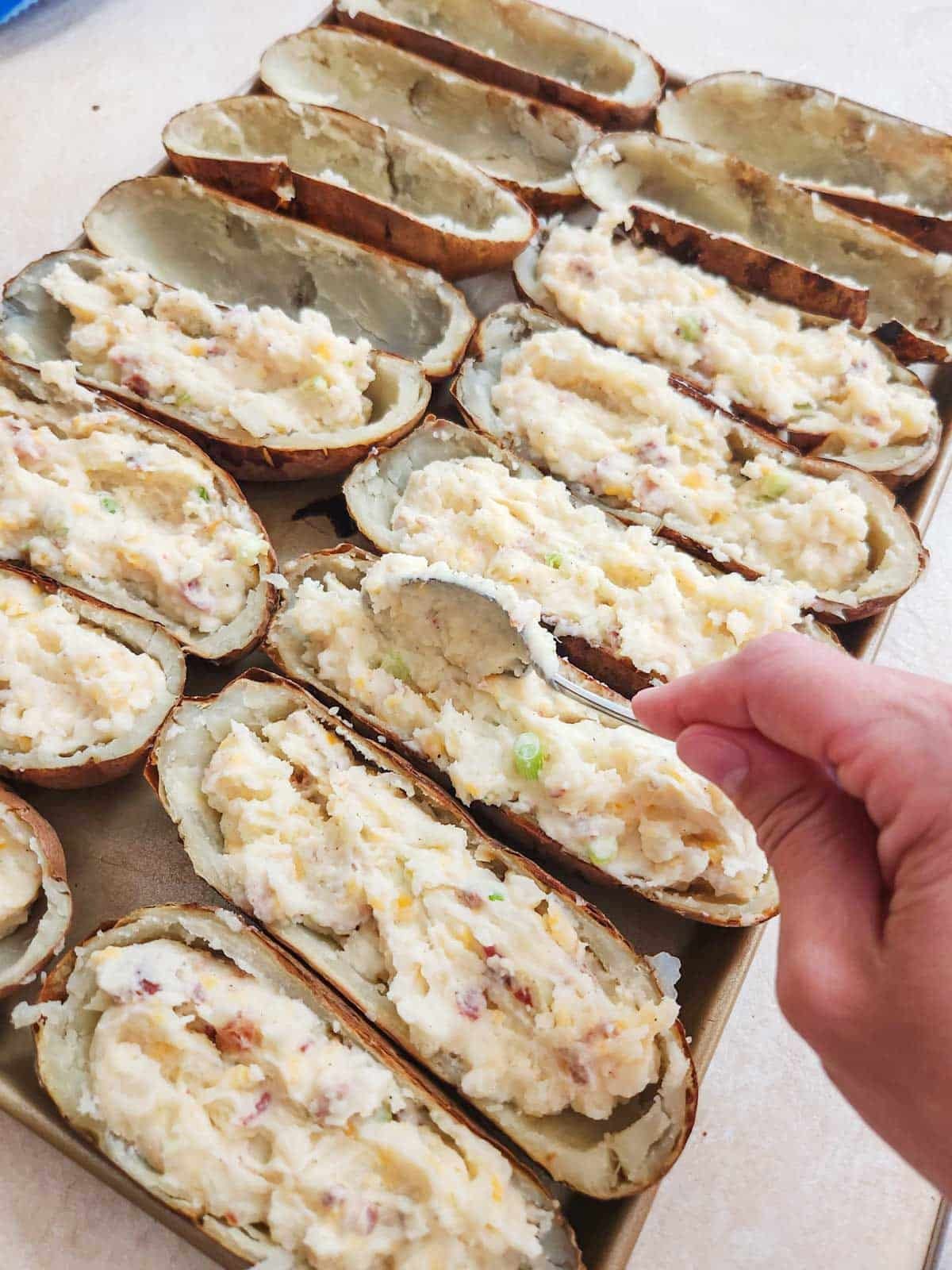 filling potato skins with the loaded baked potato filling 
