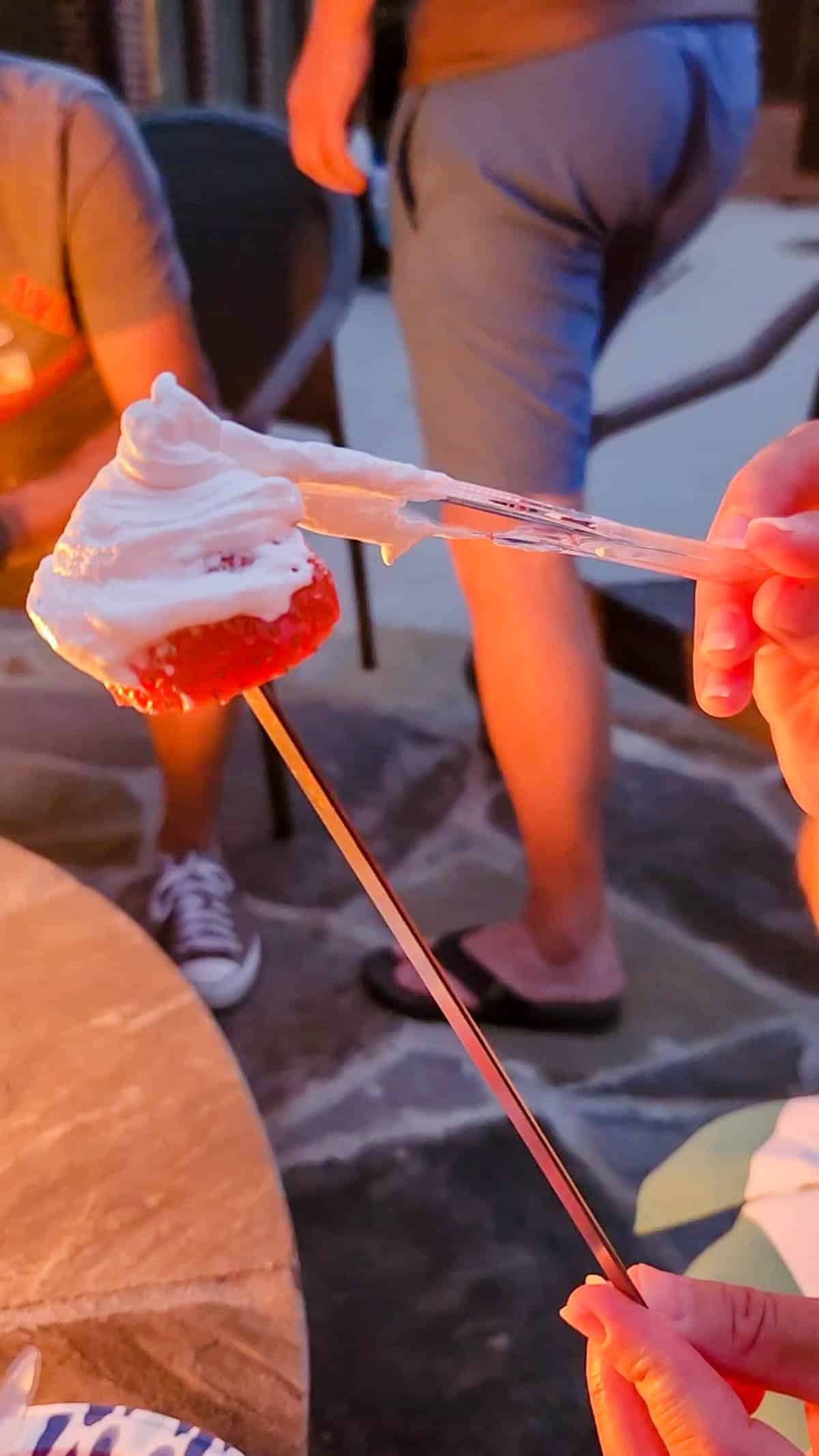 smearing marshmallow fluff on a strawberry