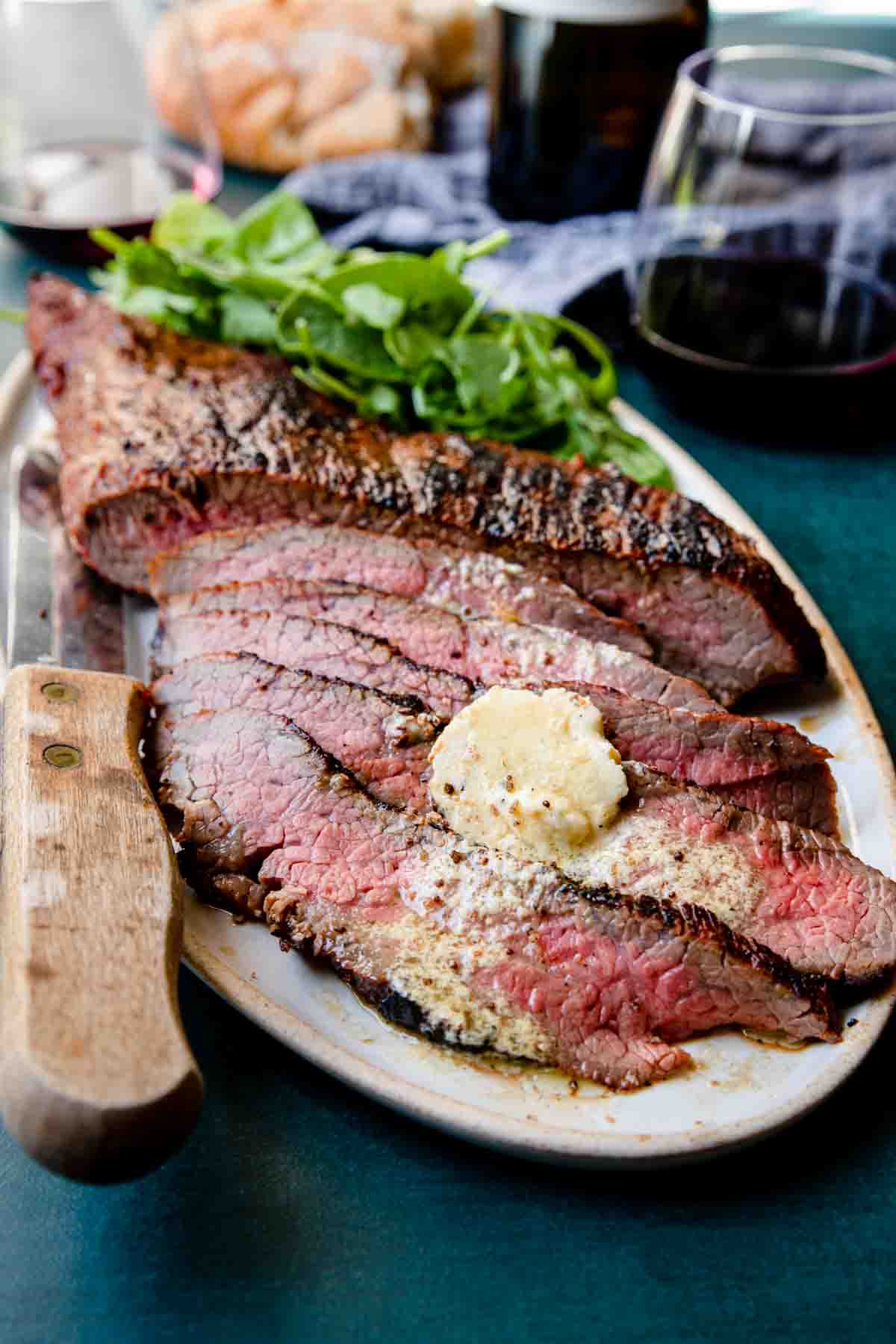 Grilled Tri Tip sliced on a platter with mustard butter melting over the slices 