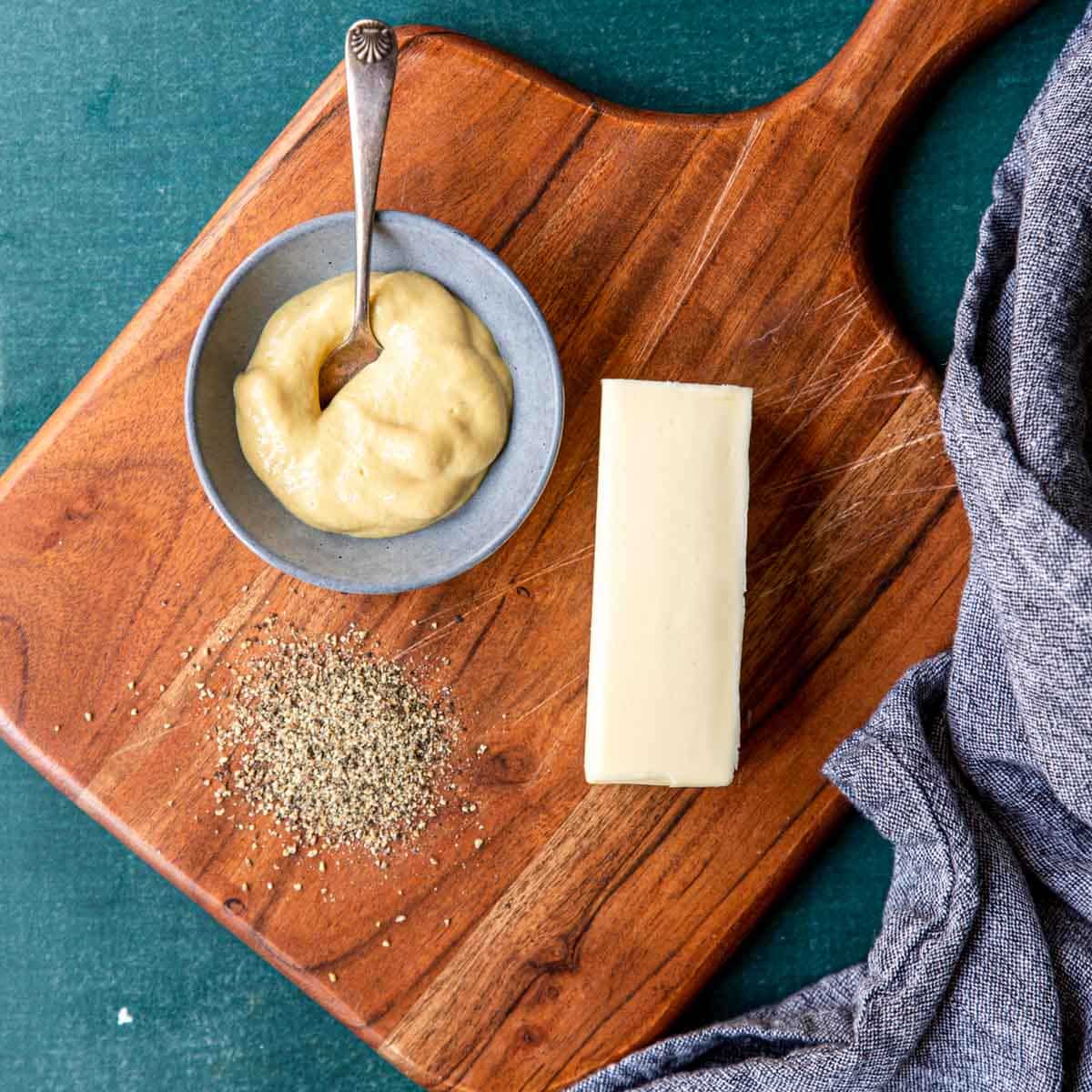 Ingredients for mustard butter on a cutting board
