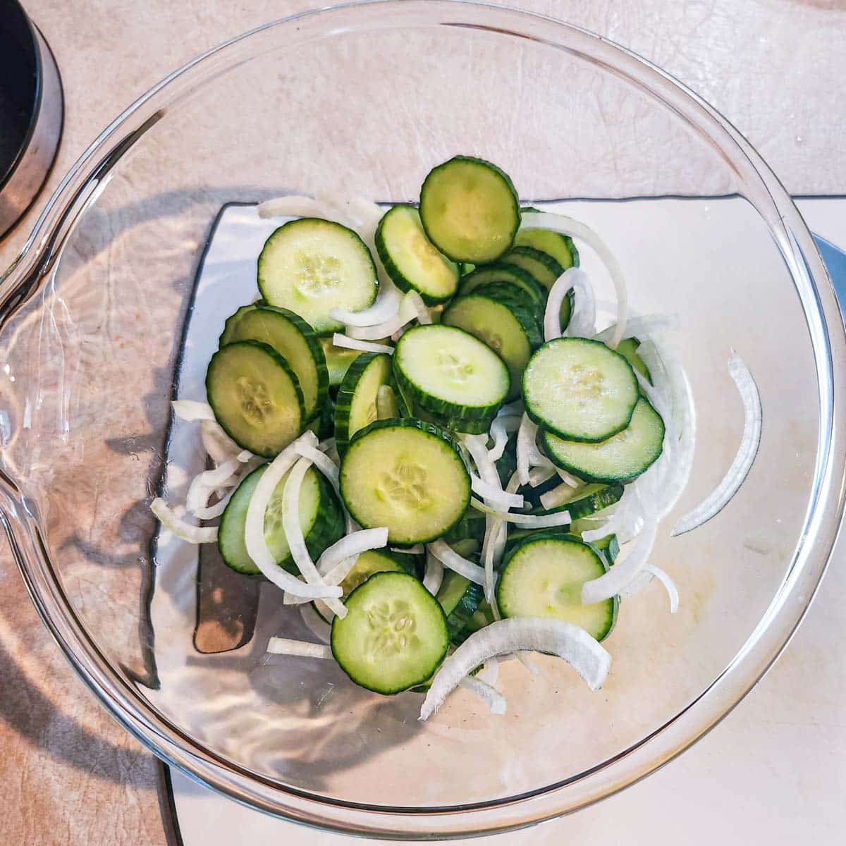 sliced cucumbers and sliced onions in a bowl